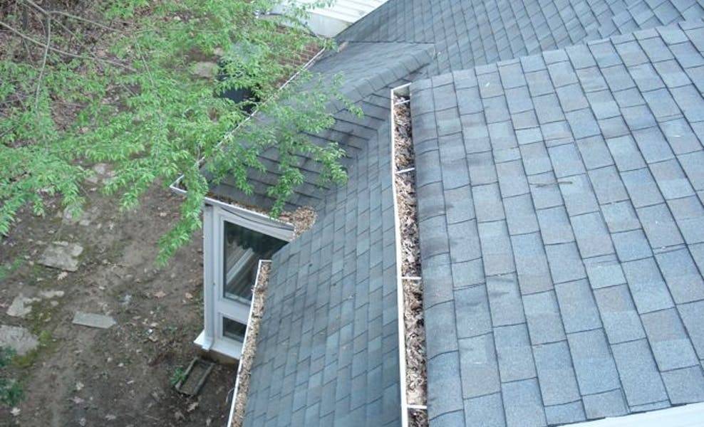 damage caused by clogged gutters overflowing water onto roof